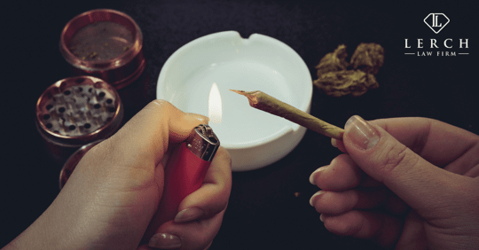 person holding a marijuana joint and lighting it