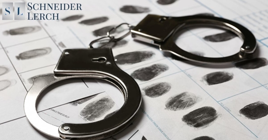 handcuffs on a paper with fingerprints