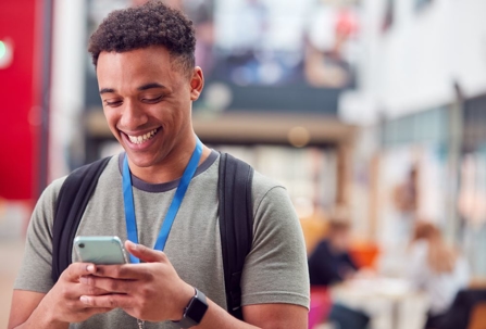 black-young-man-smiling-looking-at-cell-phone